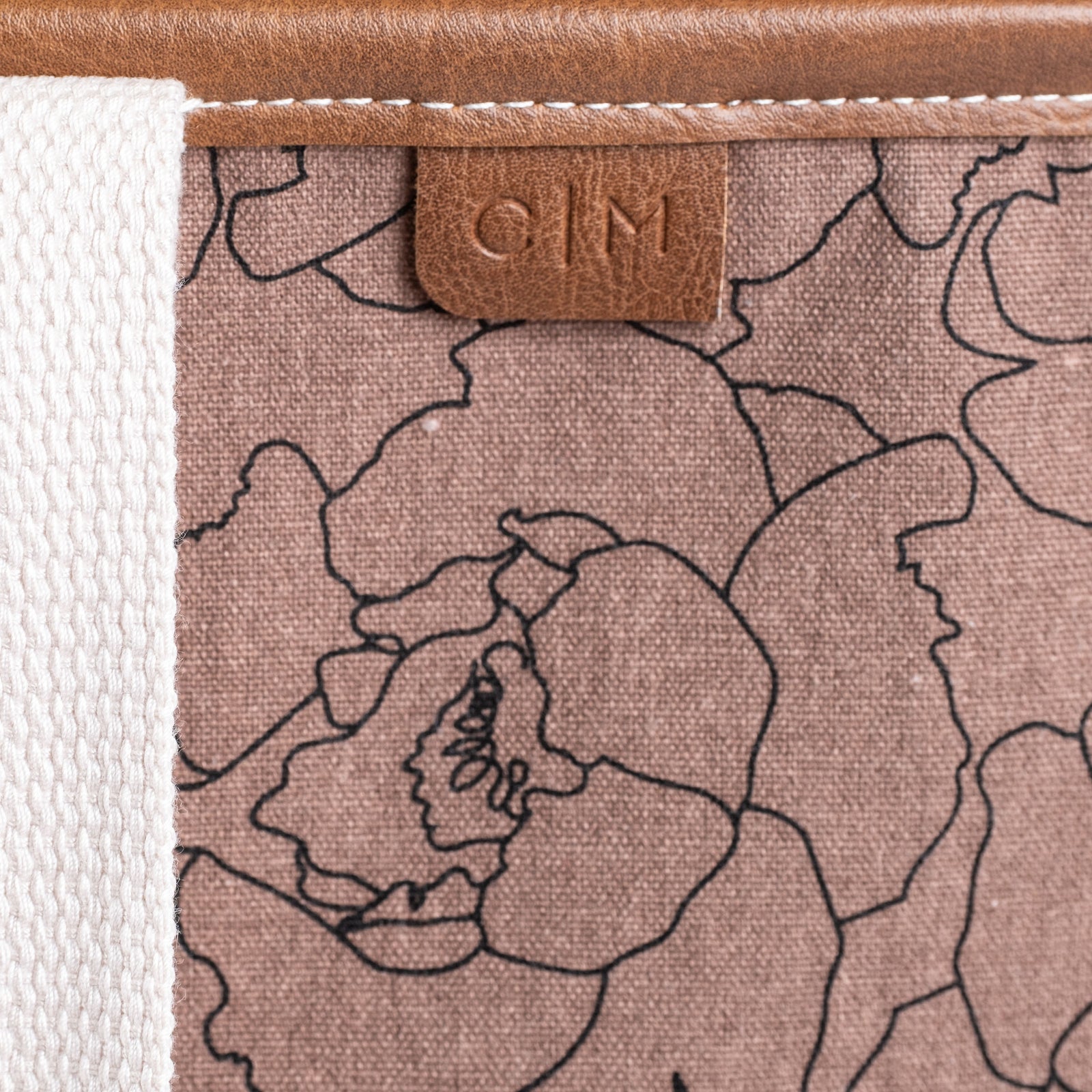 Floral patterned tote bag with a brown leather tag displaying C|M