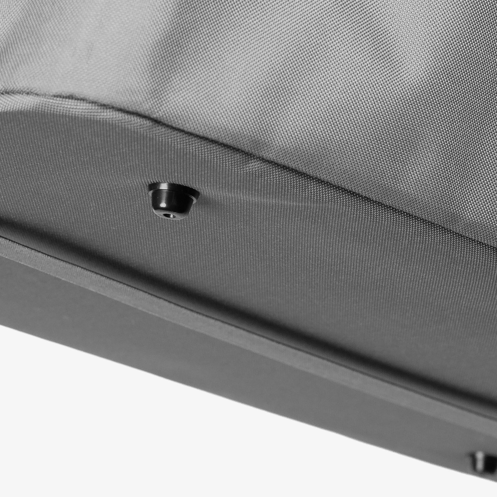 Close-up of a gray fabric surface with a small black object on it.
