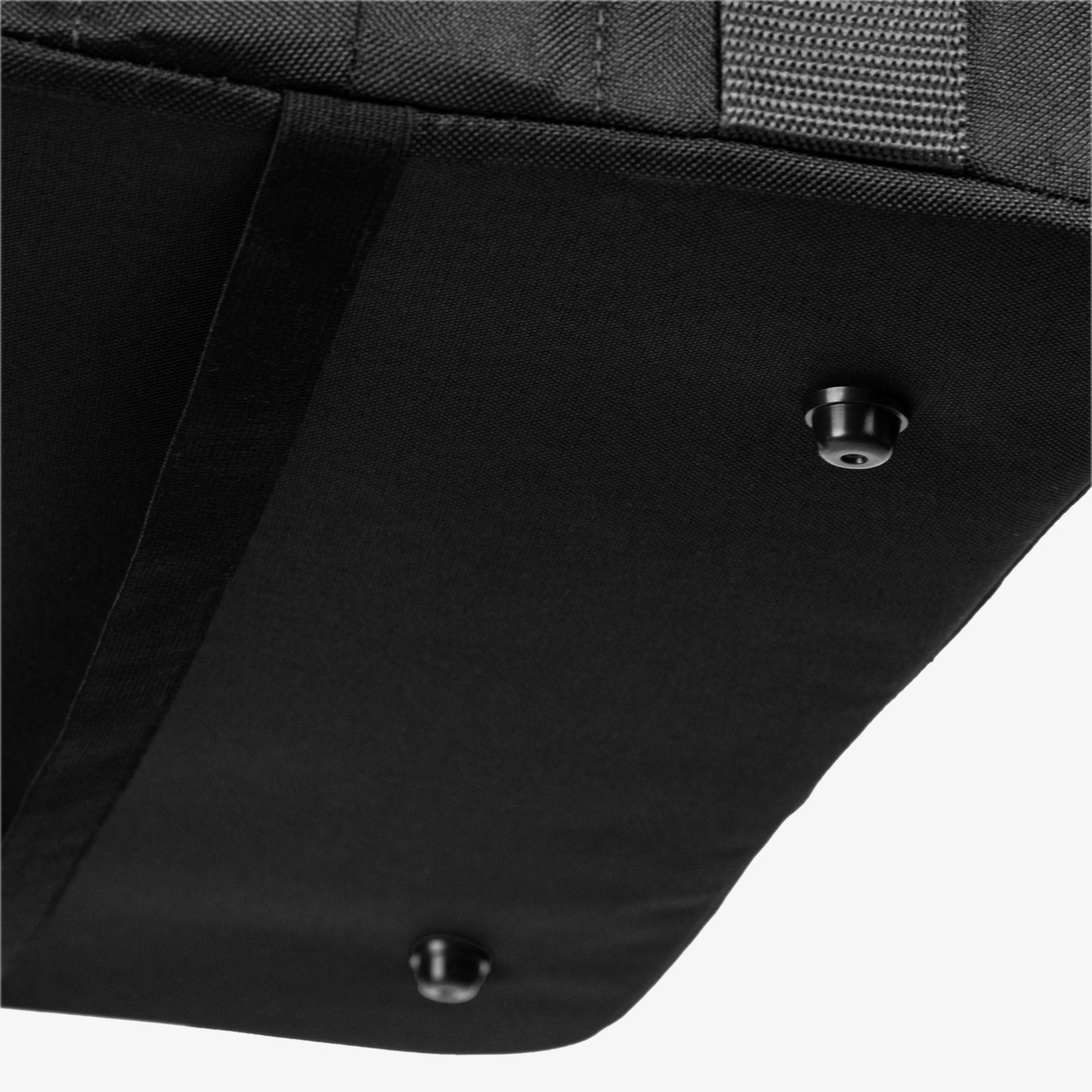 Close-up of a black bag with metal rivets on a white background