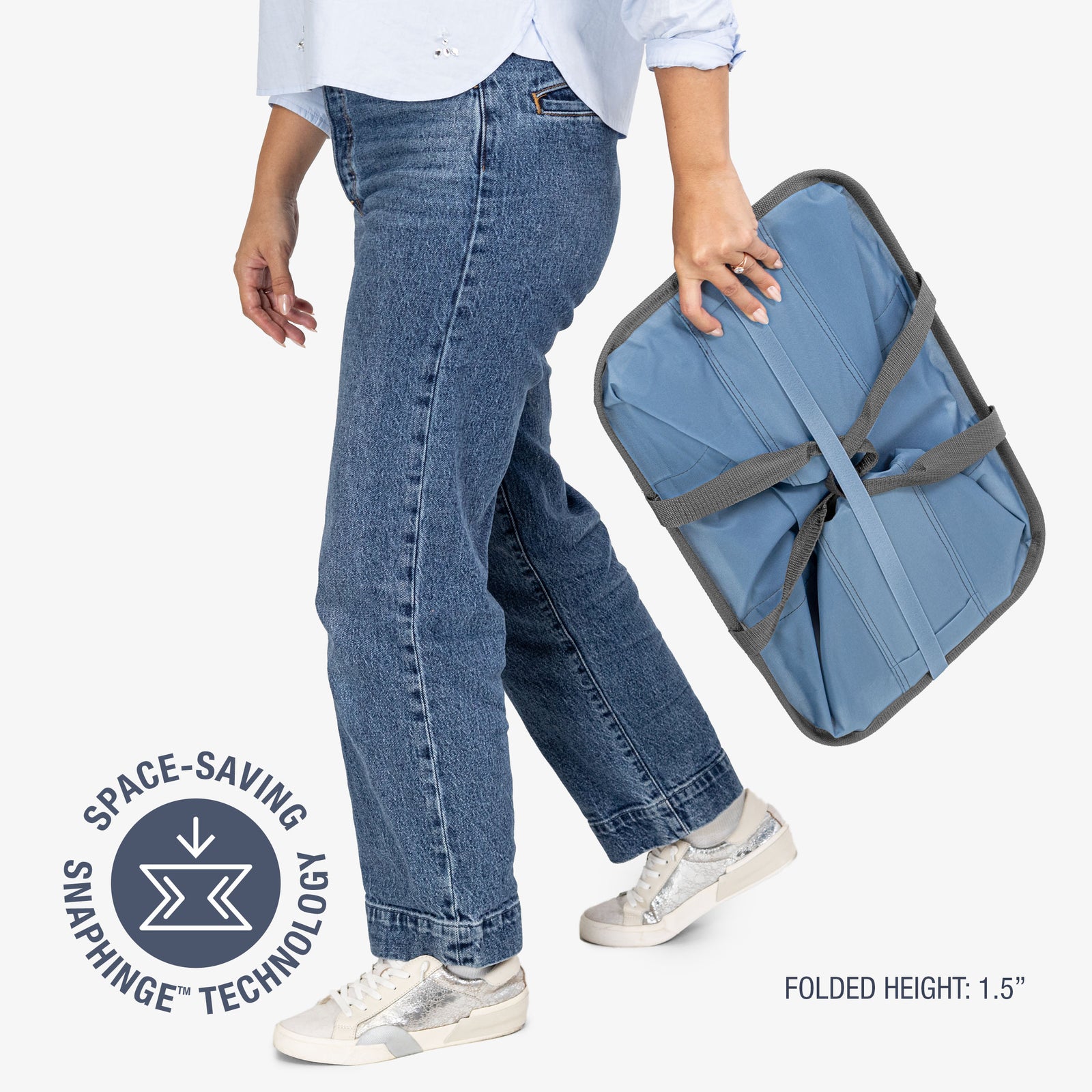 Person holding a blue folding laundry tote bag with 'Space-Saving Snap Hinge Technology' label.