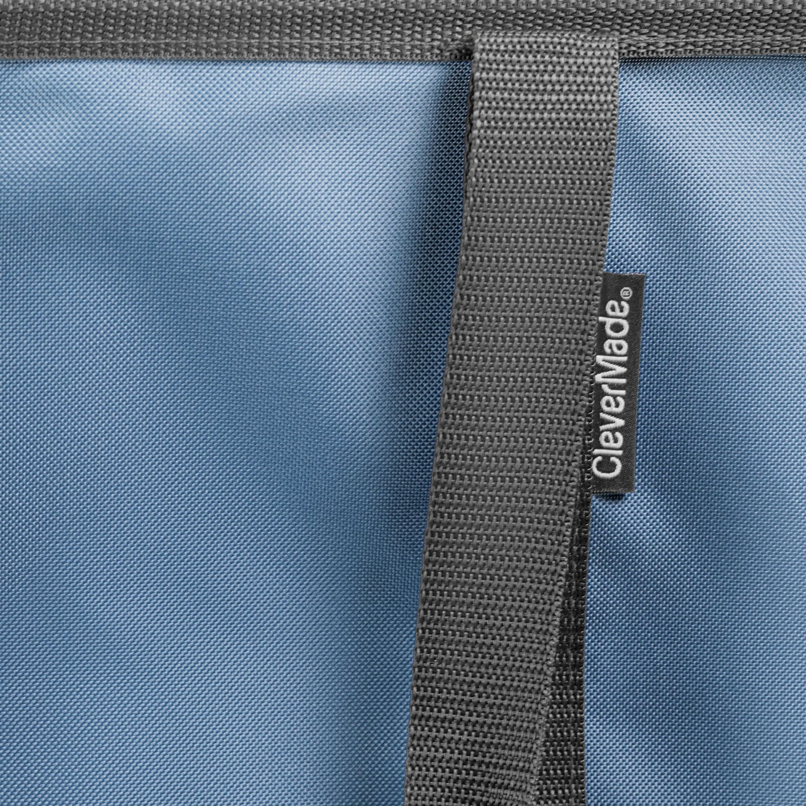 Close-up of a blue bag with a gray strap and CleverMade logo.