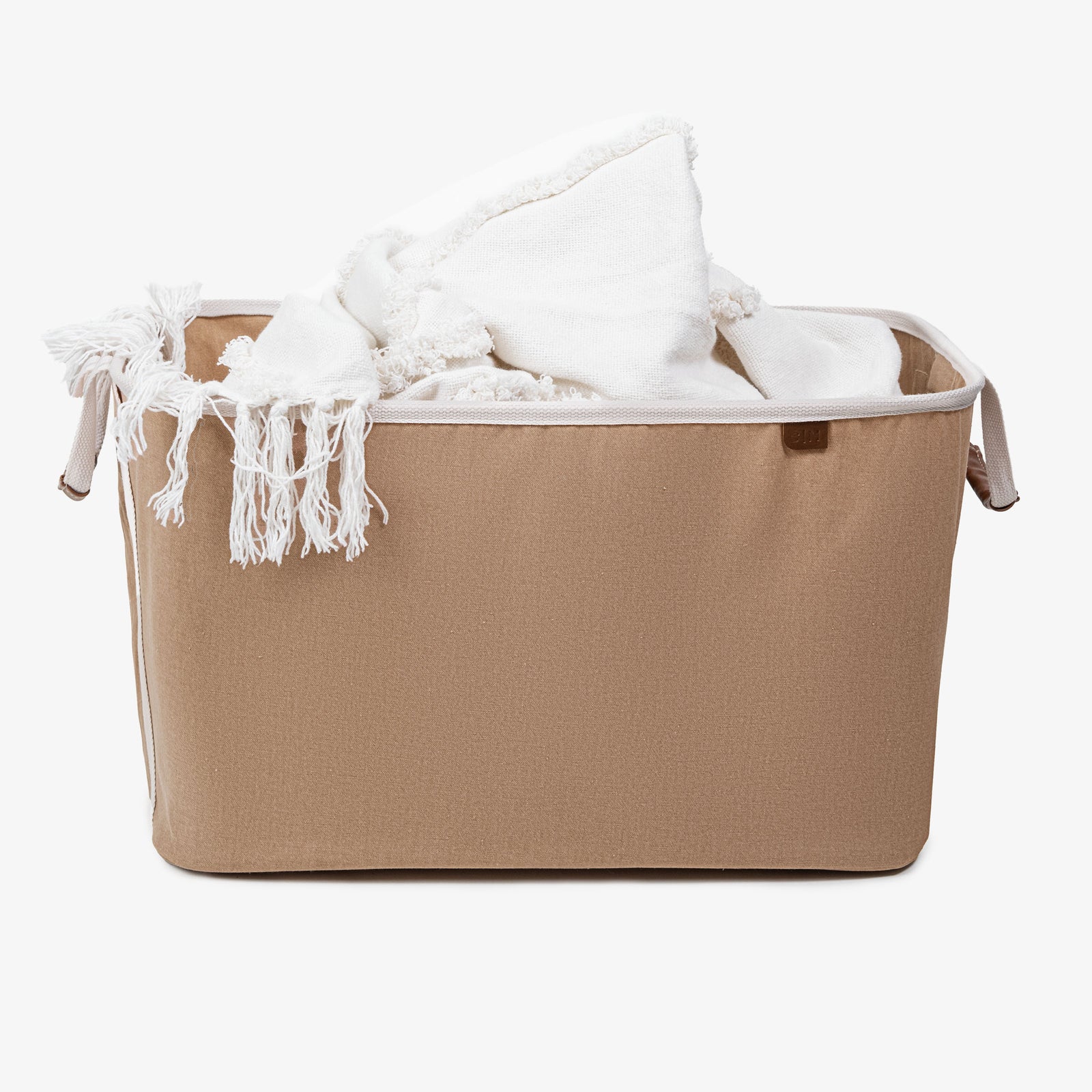 A blanket inside the cream collapsible laundry basket LUXE with cream handle strap