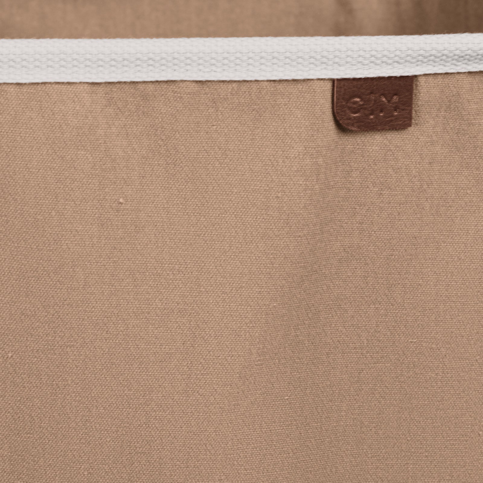 Close up collapsible laundry basket LUXE with brown brand label C|M