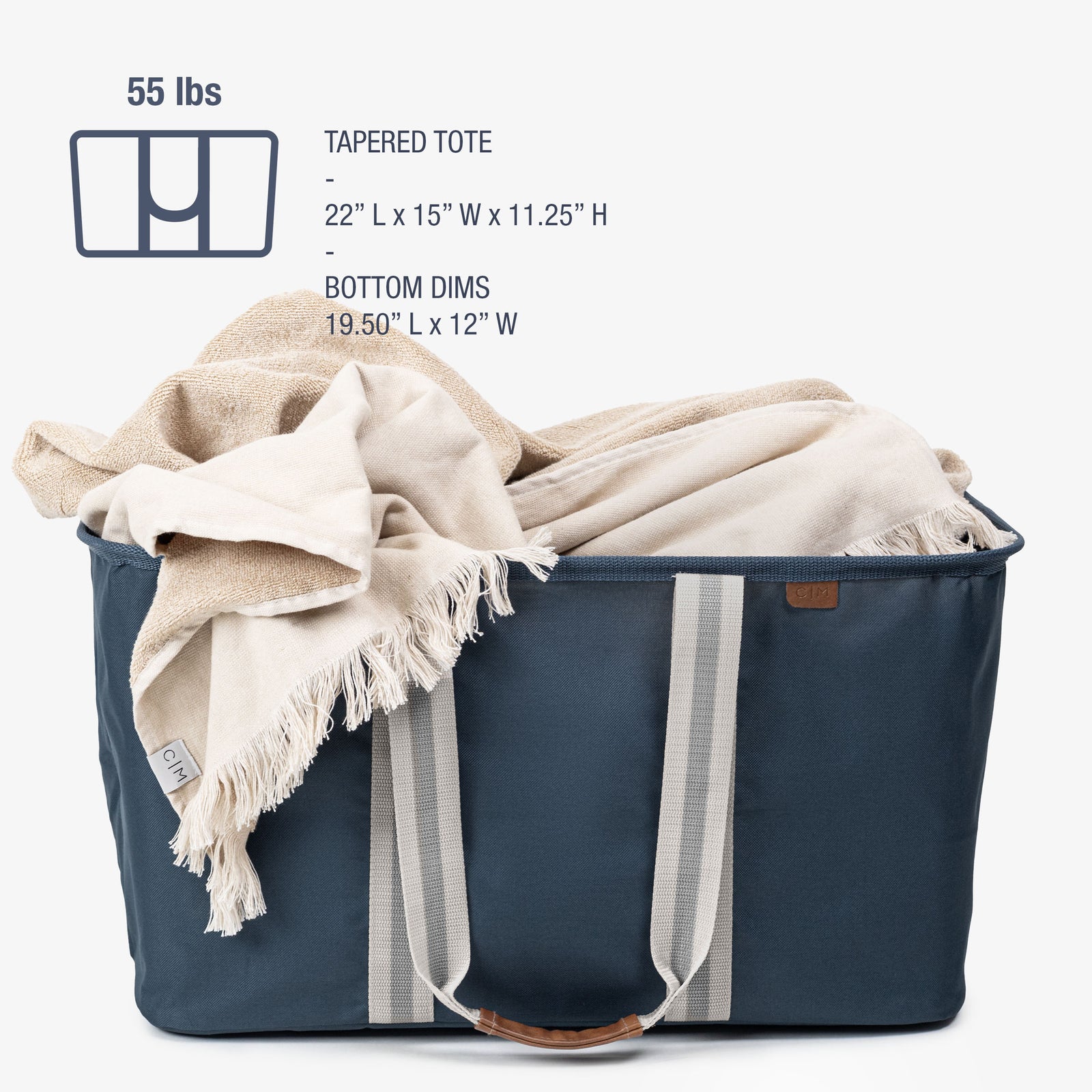 Navy tapered tote with a beige blanket draped over it on a white background