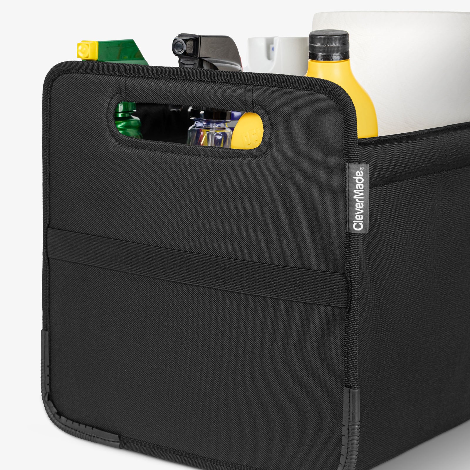 Black car trunk caddy with items inside on a white background