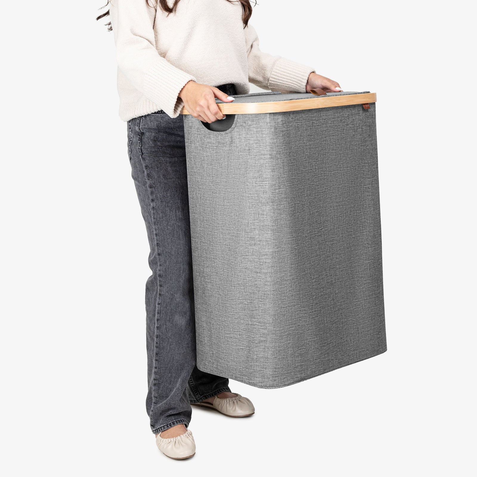 Person holding a large gray laundry basket on a white background