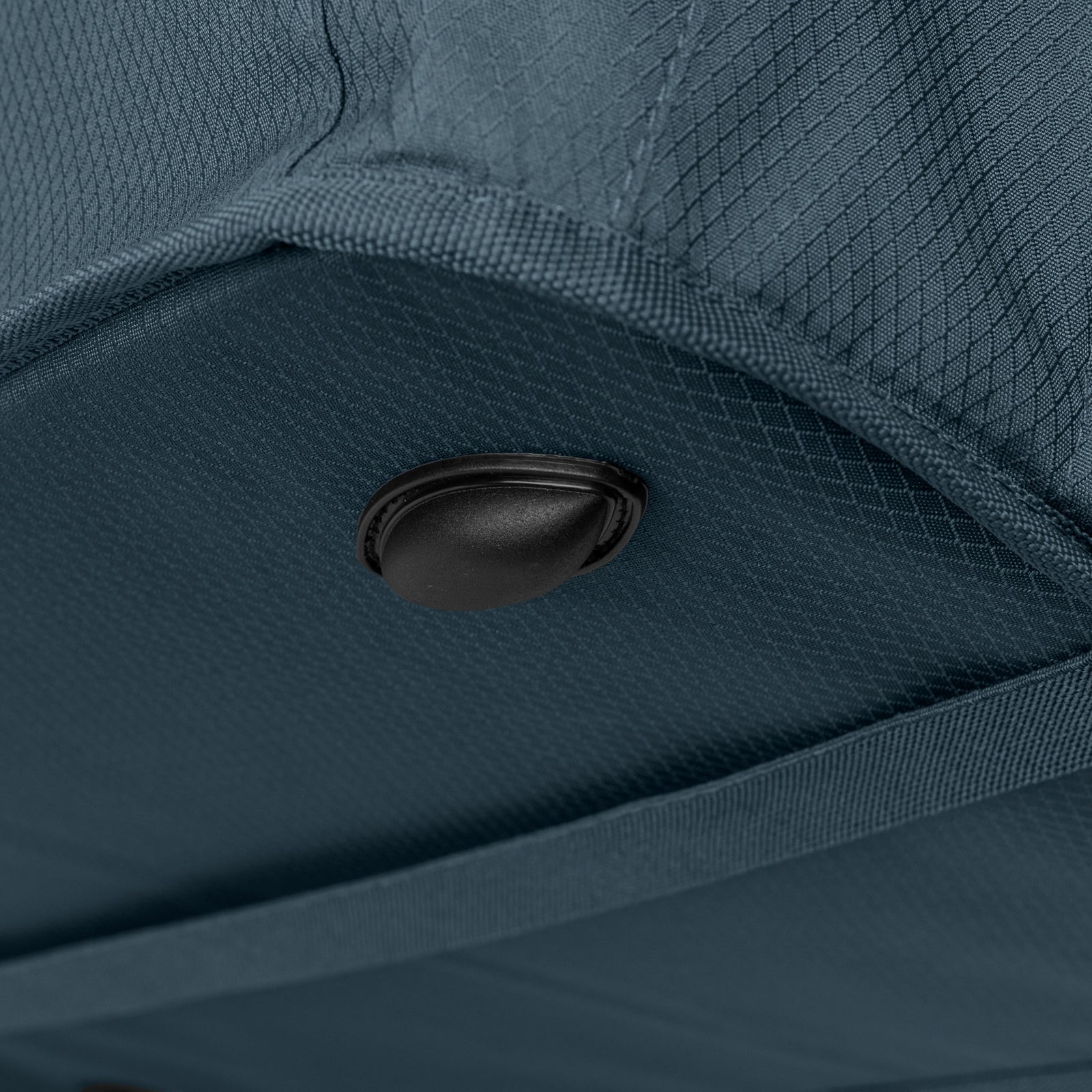 Close-up of a blue bag with a black button detail