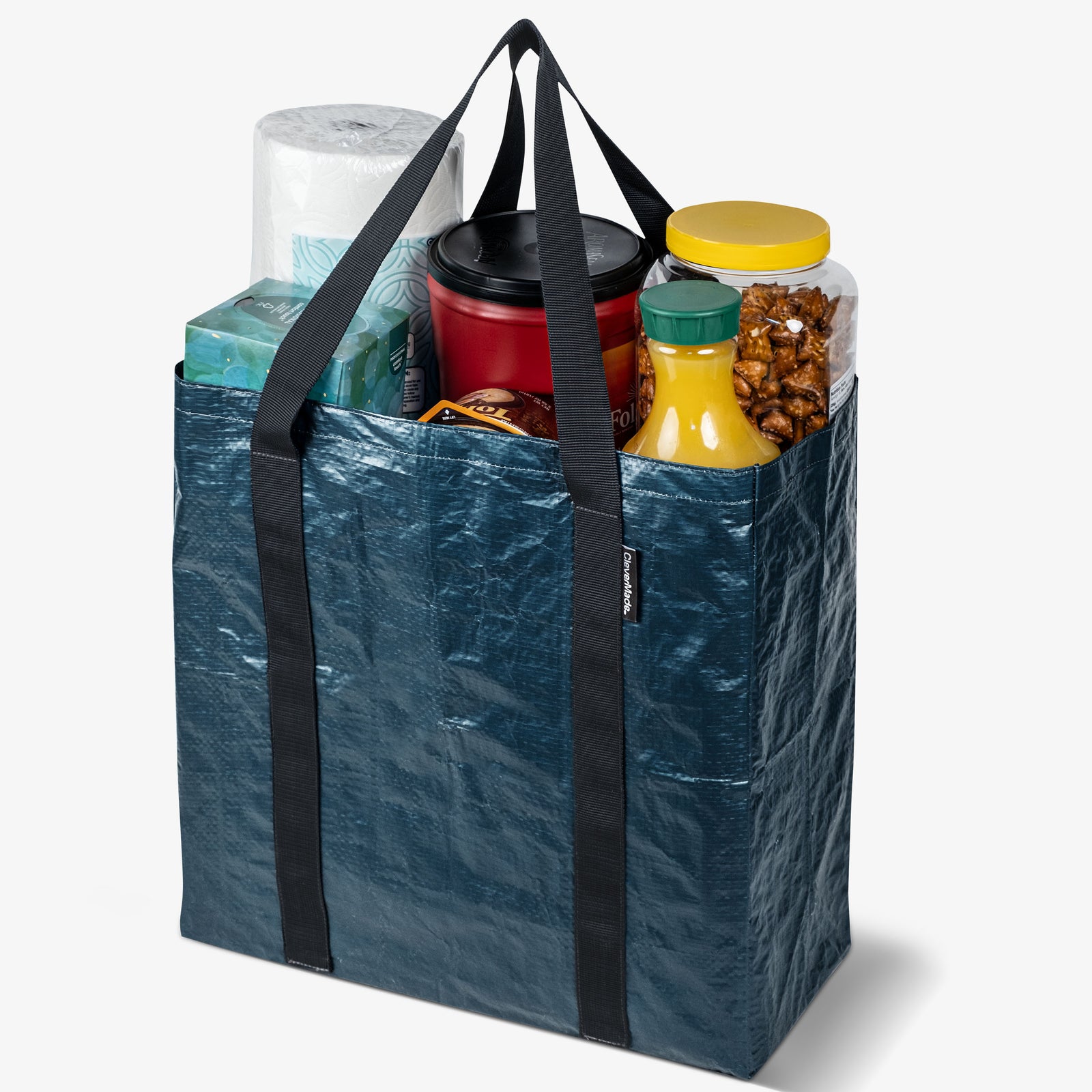 Blue reusable shopping bag filled with groceries on a white background