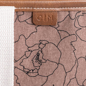 Floral patterned tote bag with a brown leather tag displaying C|M
