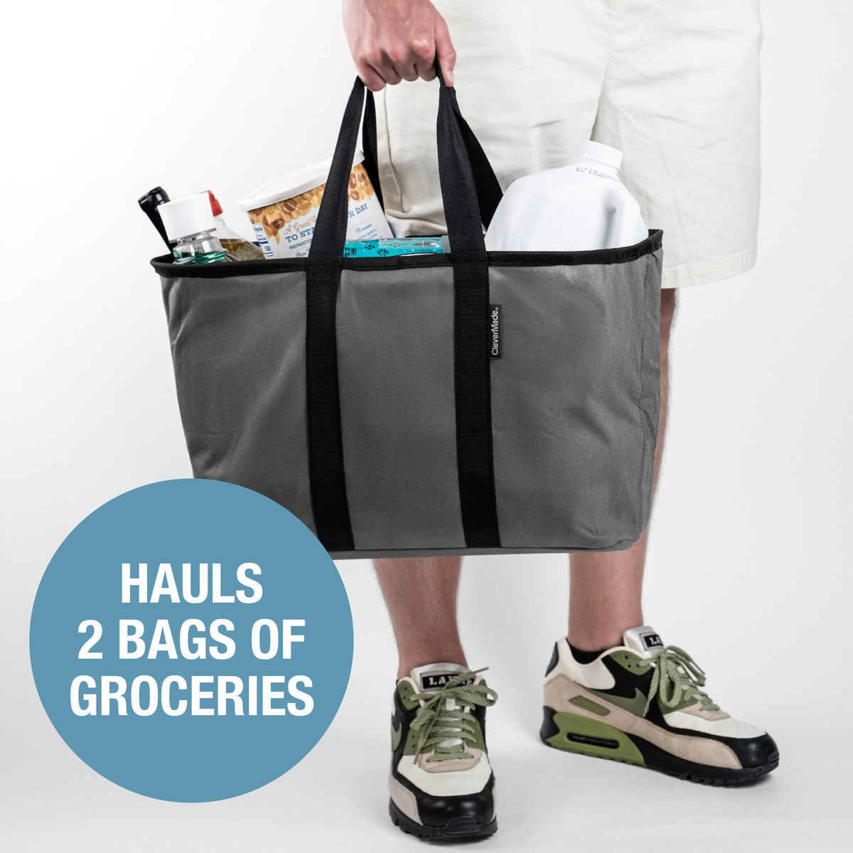 A person holding a gray and black pop-up tote with groceries