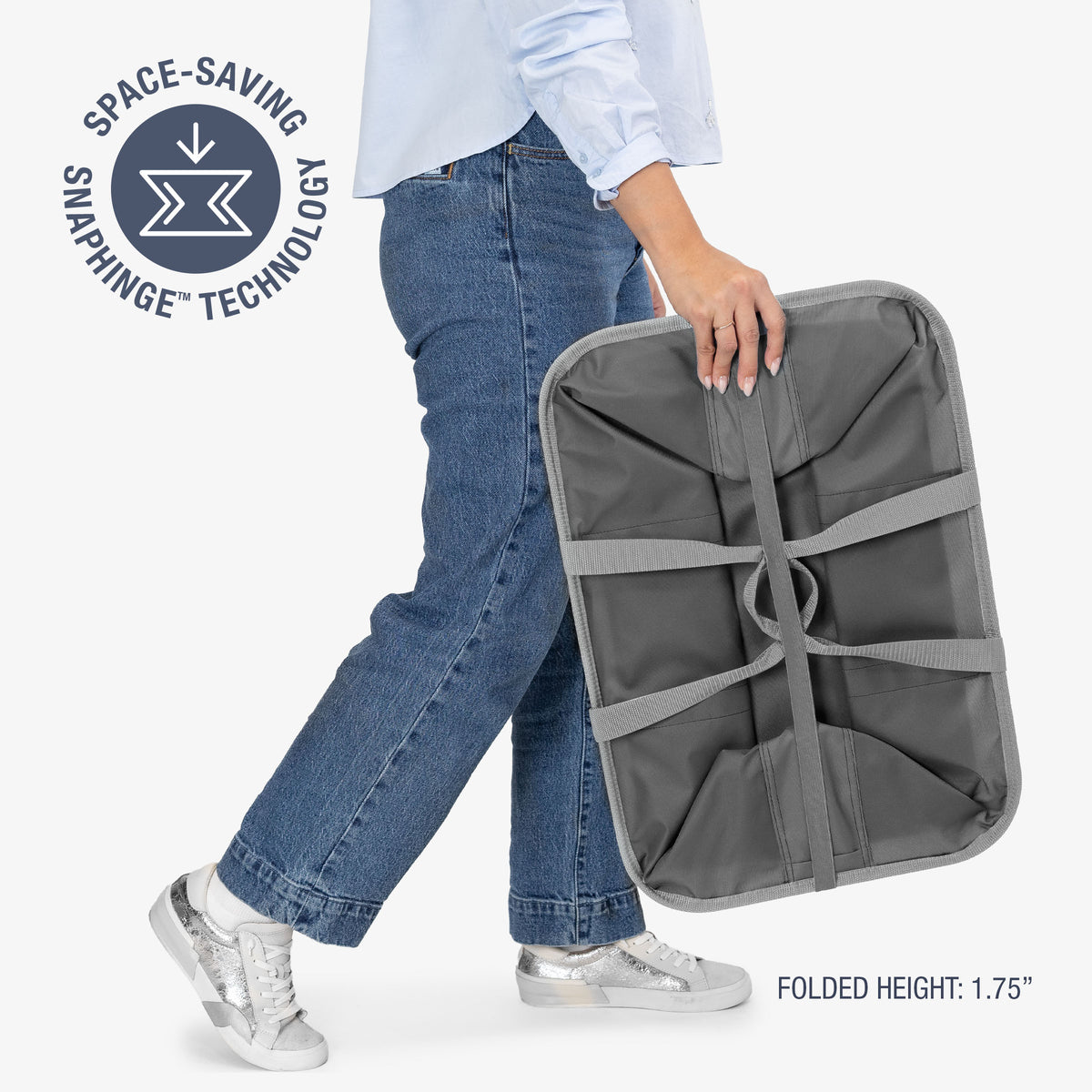 Person holding a gray space-saving laundry caddy with text about snaphinge technology on a white background