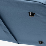 Close-up of a blue fabric surface with a black button-like object.
