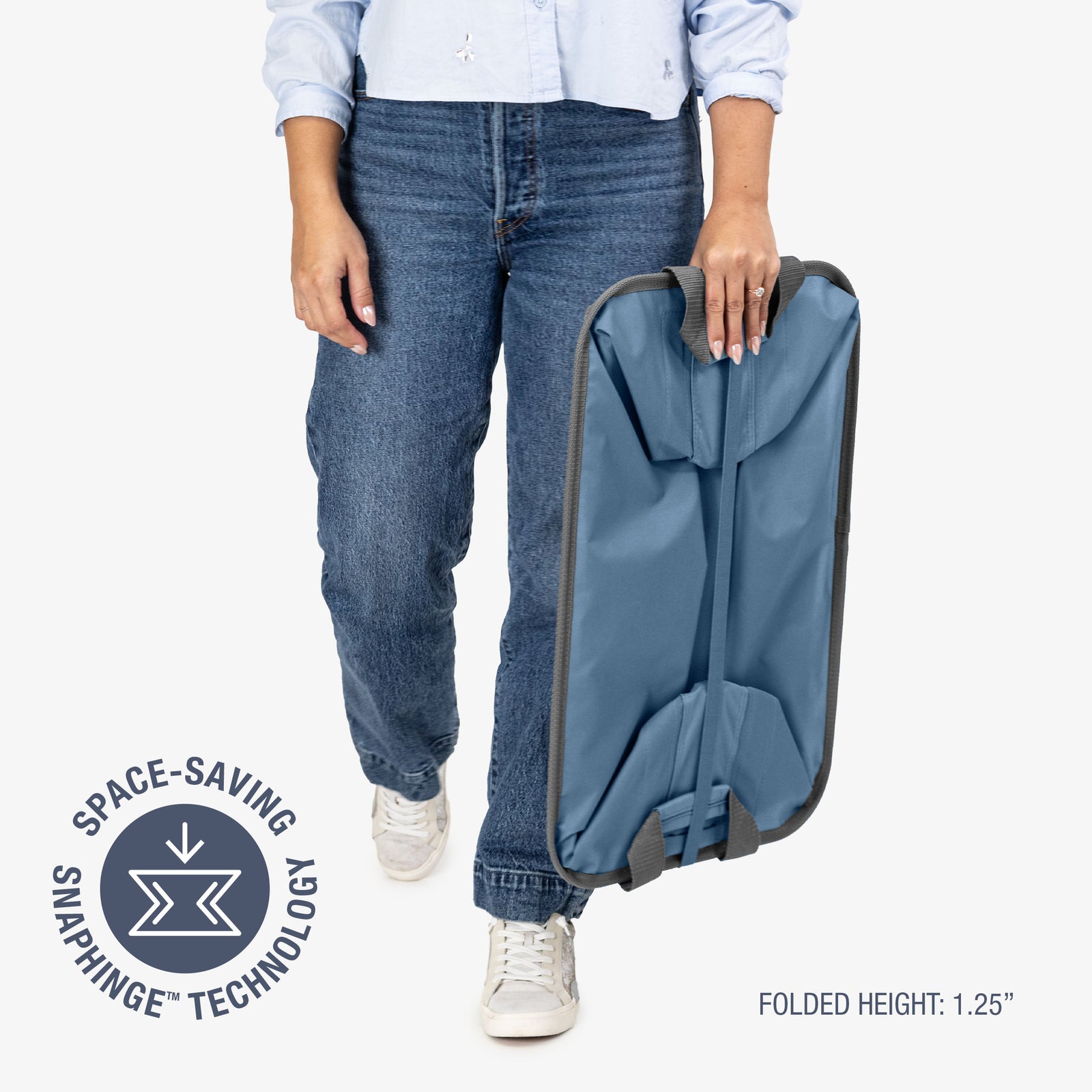 Person holding a blue folded collapsible laundry basket with space-saving snaphinge technology label