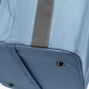 Close-up of a blue collapsible laundry basket with a brown strap on a white background