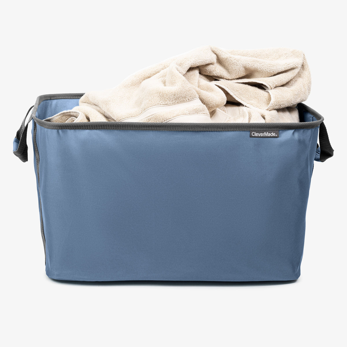 Blue collapsible laundry basket with a beige blanket inside on a white background