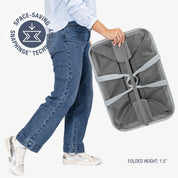 Person holding a gray folding chair with 'Space-Saving Snap hinge Technology' label.