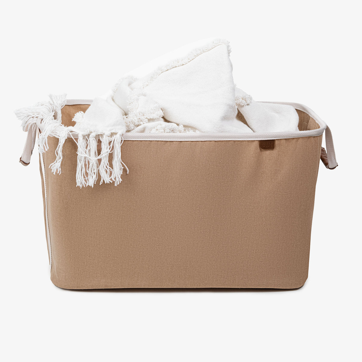 A blanket inside the cream collapsible laundry basket LUXE with cream handle strap