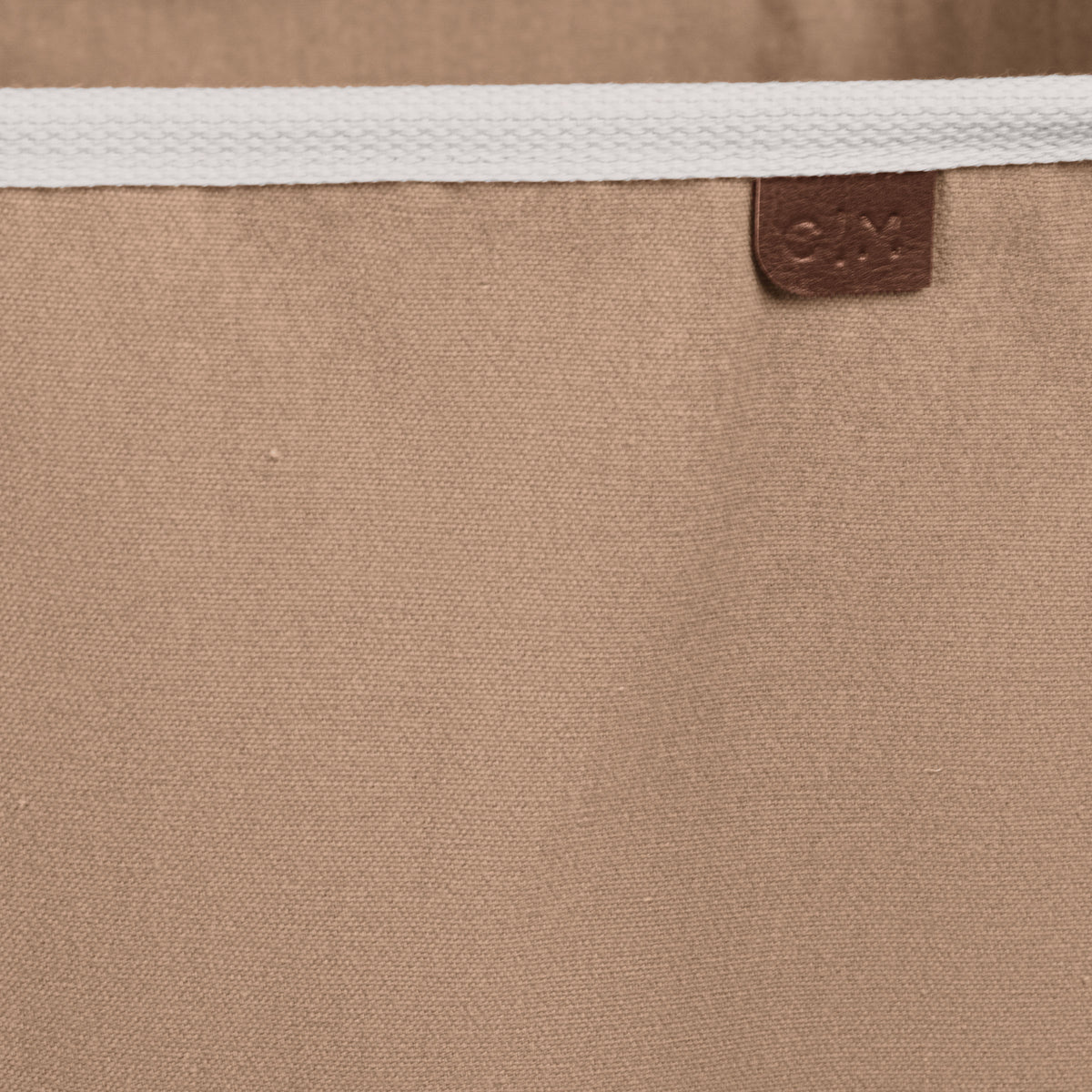 Close up collapsible laundry basket LUXE with brown brand label C|M