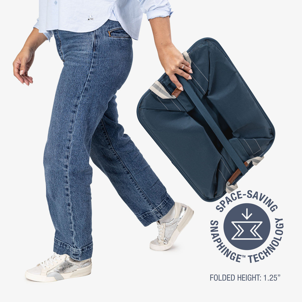 Person holding a navy blue collapsible laundry basket with space-saving snaphinge technology label