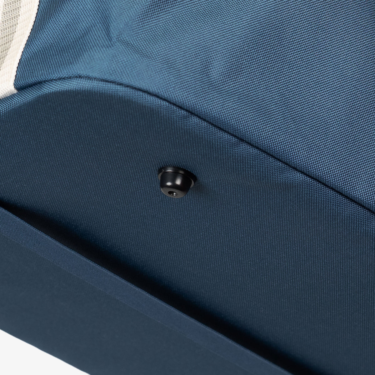 Close-up of a blue collapsible laundry basket with a button foot