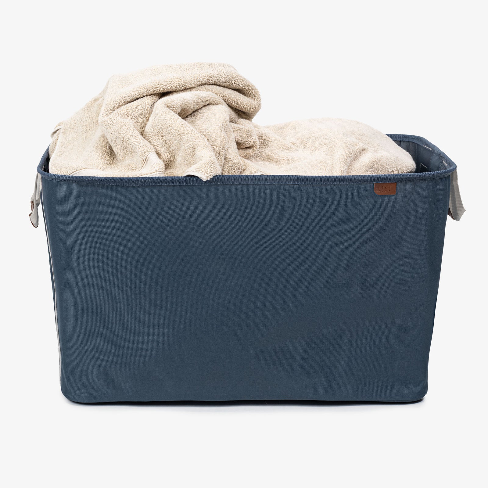 Blue collapsible laundry basket
 with beige blanket on a white background