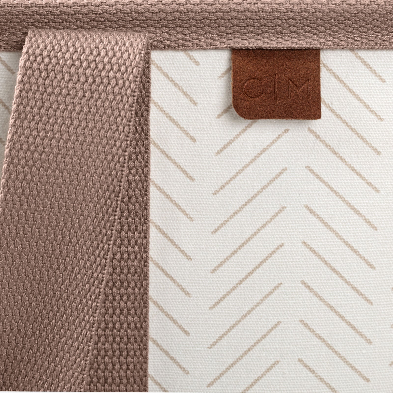 Close-up of a product with a brown textured strap and a patterned surface, featuring a brand logo.