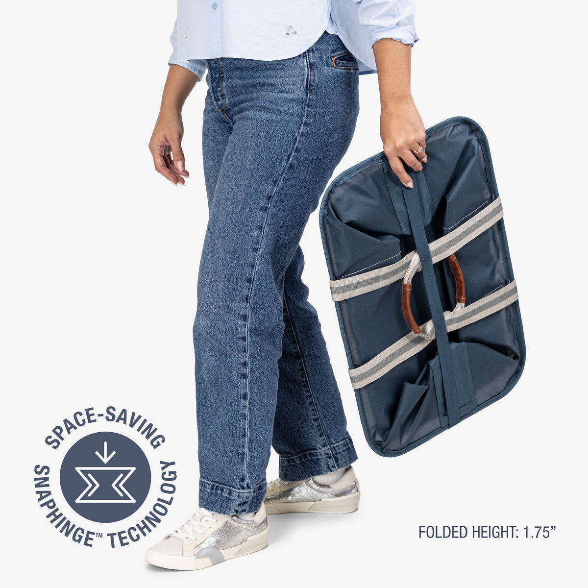 Person holding a folded navy blue laundry caddy with space-saving snapping technology label