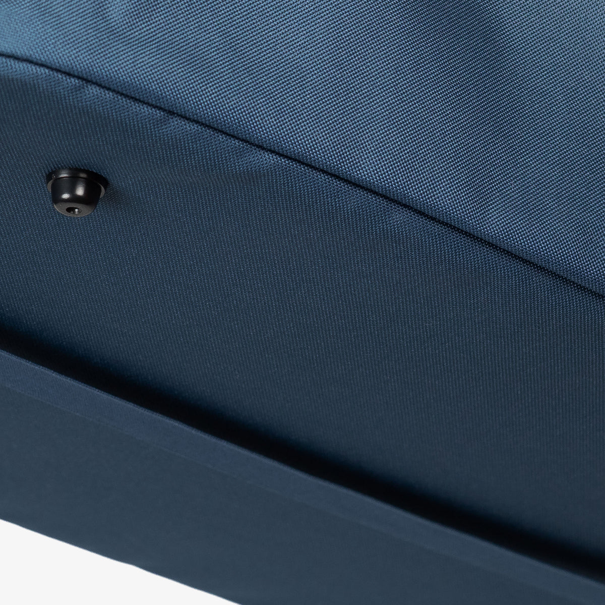 Close-up of a blue fabric surface with a button detail