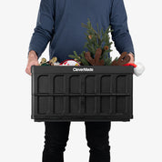 Person holding a black CleverMade crate with Christmas decorations on a white background