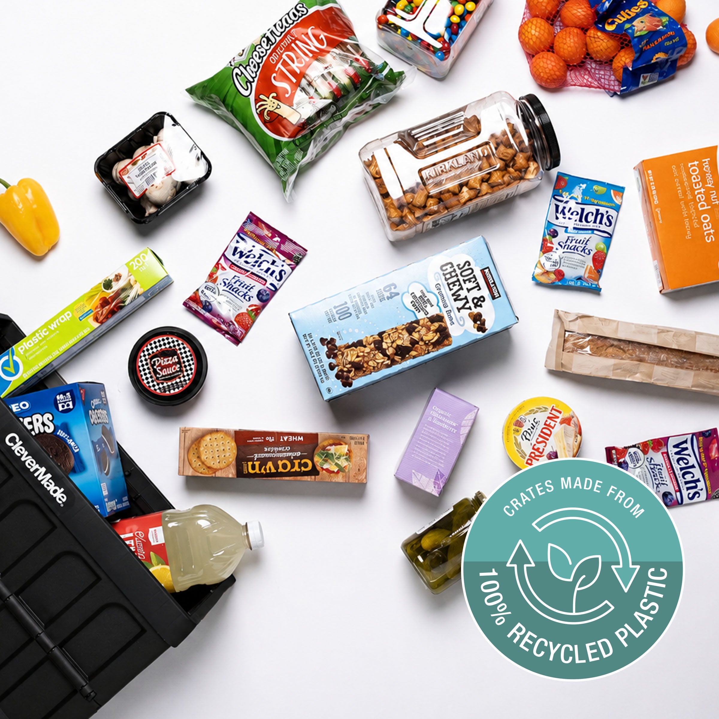 Assorted snacks and food items on a white surface with a '100% Recycled Plastic' logo.