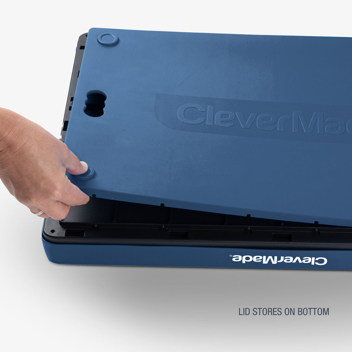 A blue and black collapsible storage bins with lid with the brand name 'CleverMade' visible on the lid that stores on the bottom