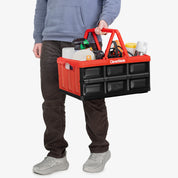 Person holding a red and black tool tote with various items on a white background