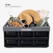 Black CleverMade storage crate with items like a hat, sunglasses, and snacks on a white background