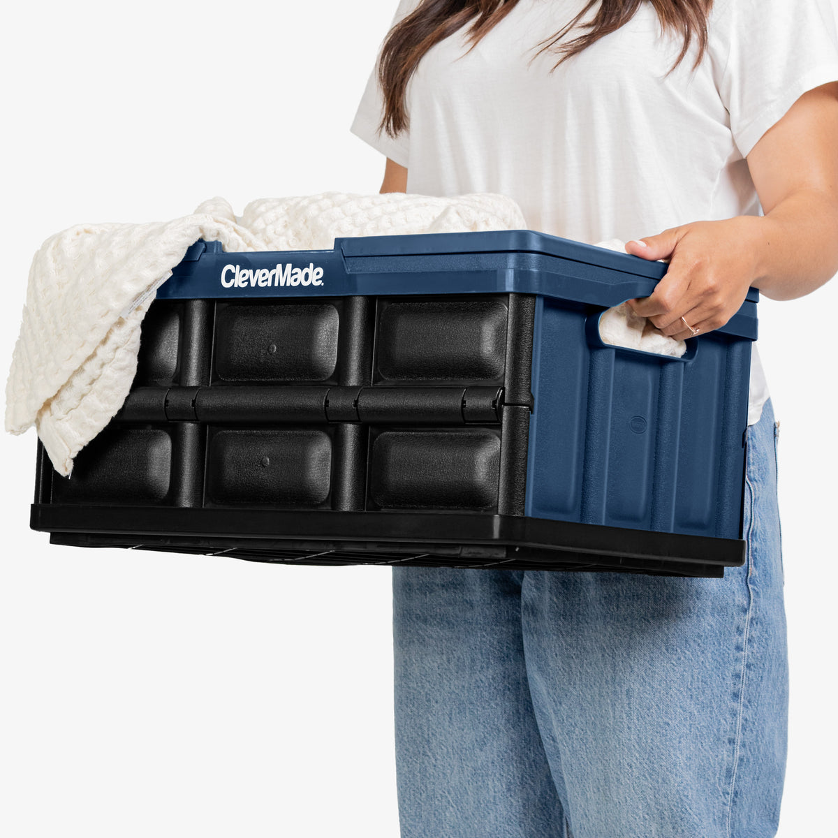 Person holding a blue and black CleverMade collapsible container.