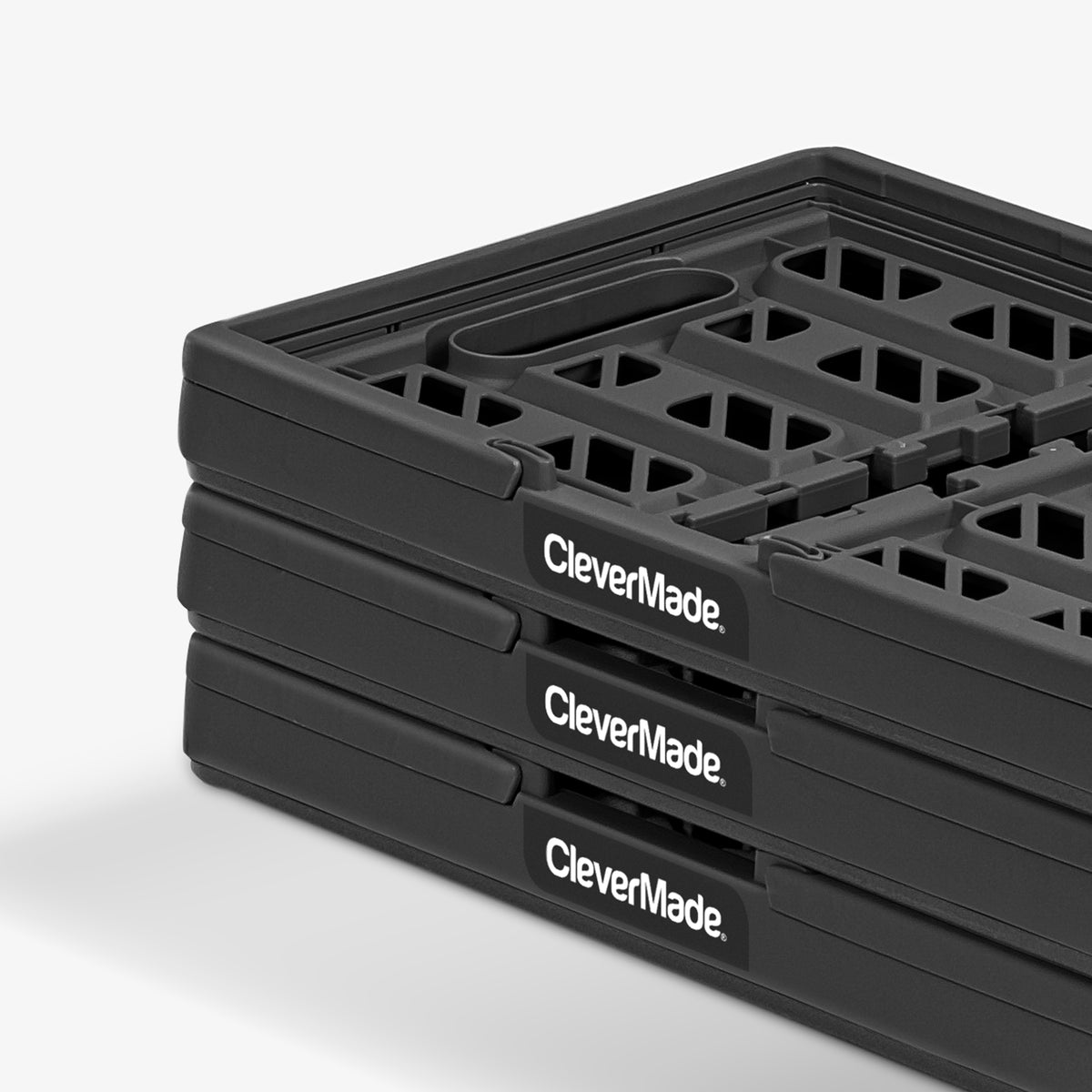 A three-pack folded 24L black collapsible shopping basket with CleverMade logo