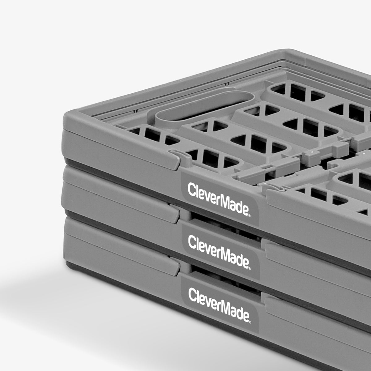 A three-pack folded gray-black collapsible shopping basket with CleverMade logo