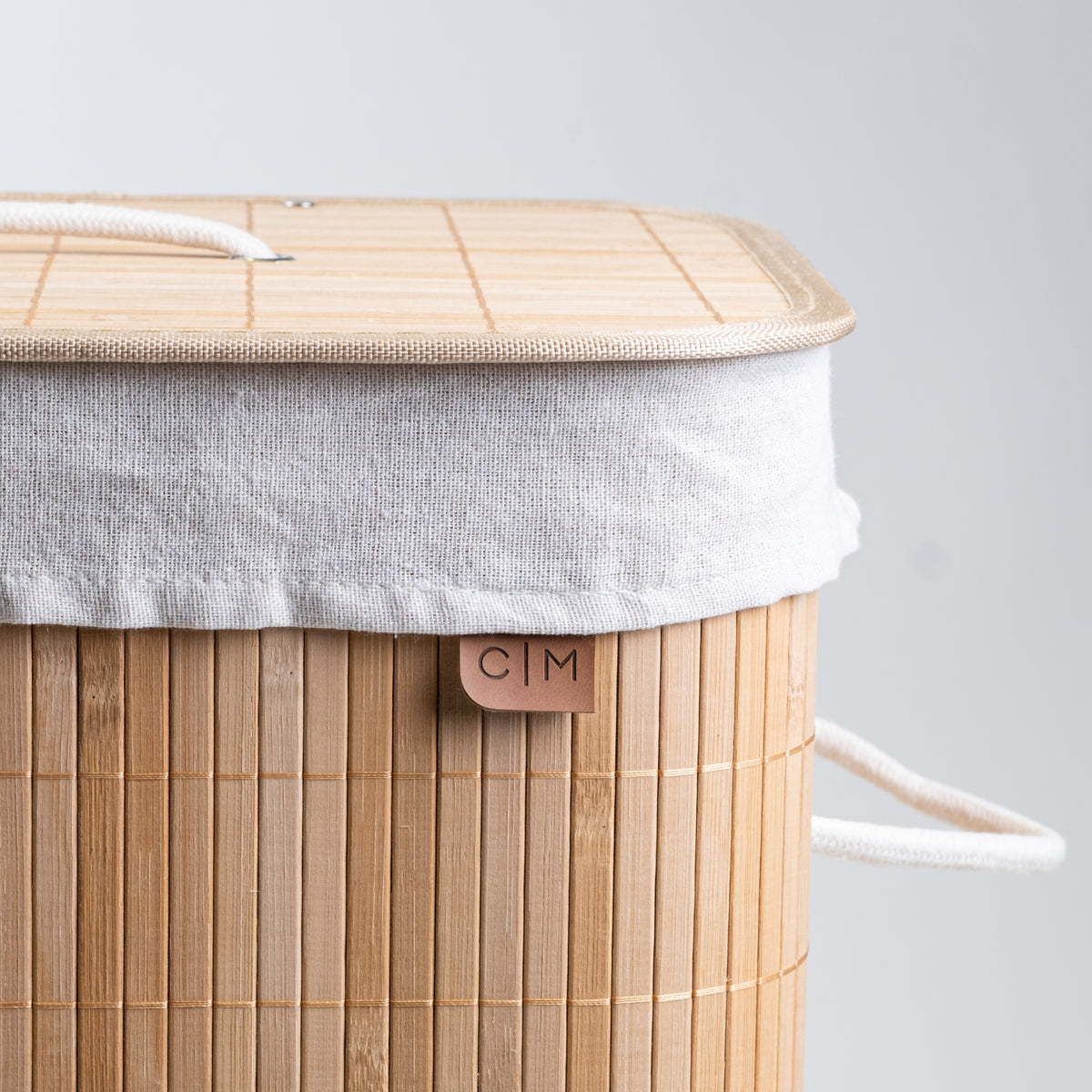 Close up view, cover of collapsible bamboo laundry hamper with a lid and handles