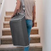 Person carrying a gray bag up a set of stairs
