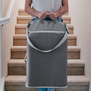 Person carrying a gray carrying case up a set of stairs