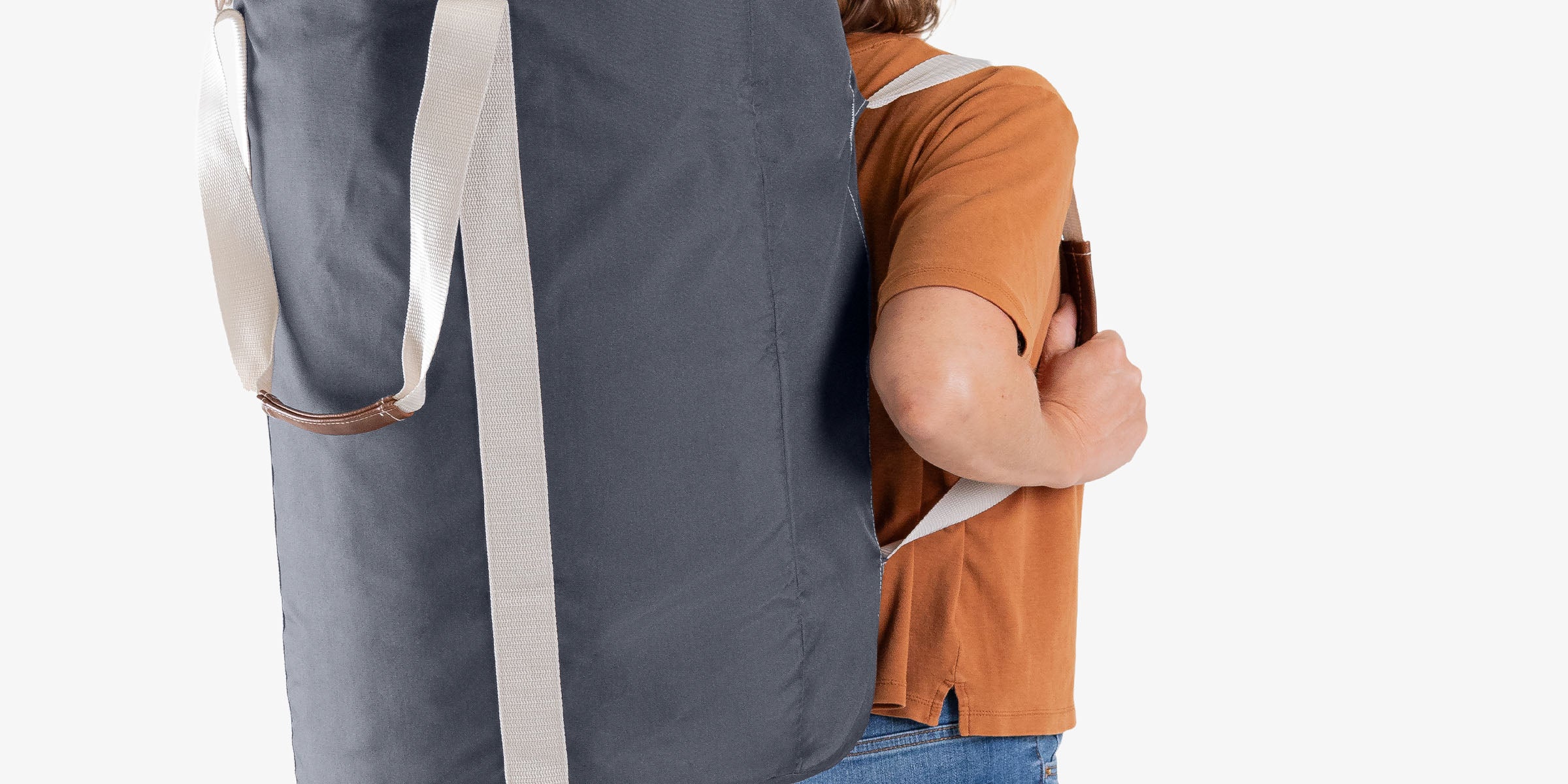 Person wearing a large gray laundry backpack duffel bag with a white top on a white background
