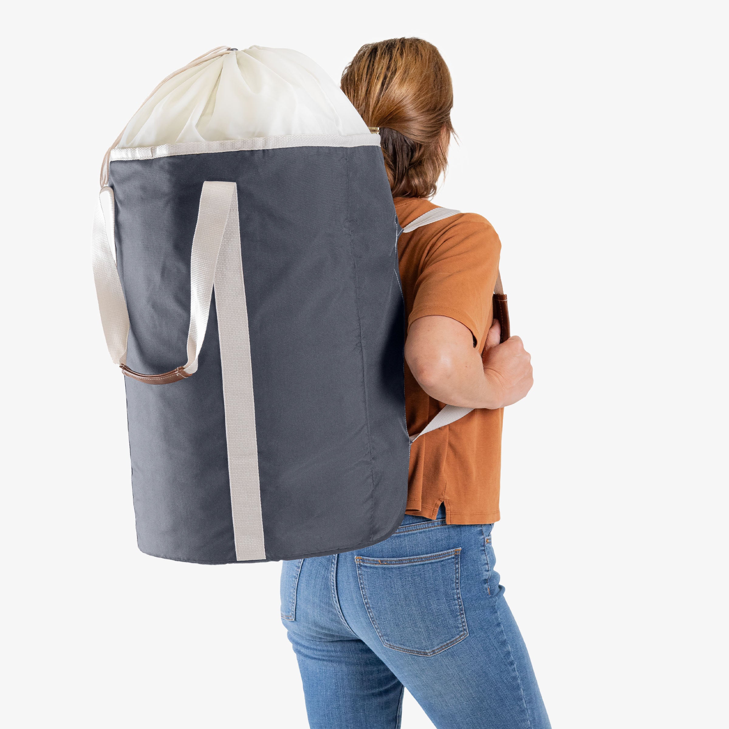 Person wearing a large gray laundry backpack duffel bag with a white top on a white background
