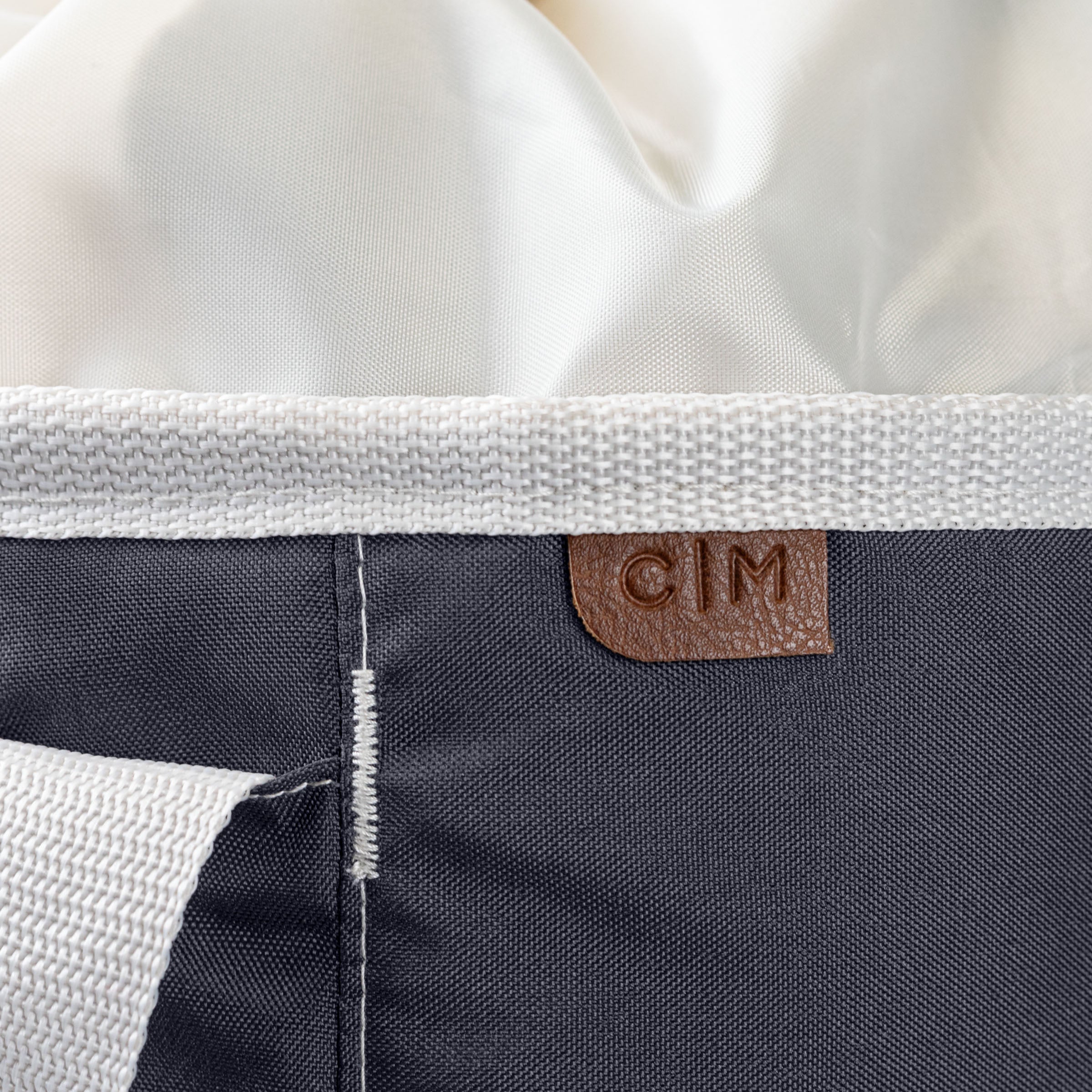 Close-up of a laundry backpack duffel bag with a visible brand label C|M on a white background