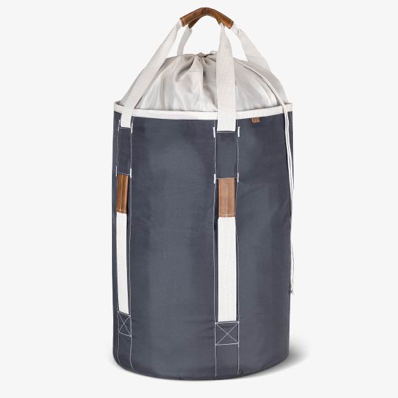 Gray laundry backpack duffel bag with white drawstring top and brown handles on a white background