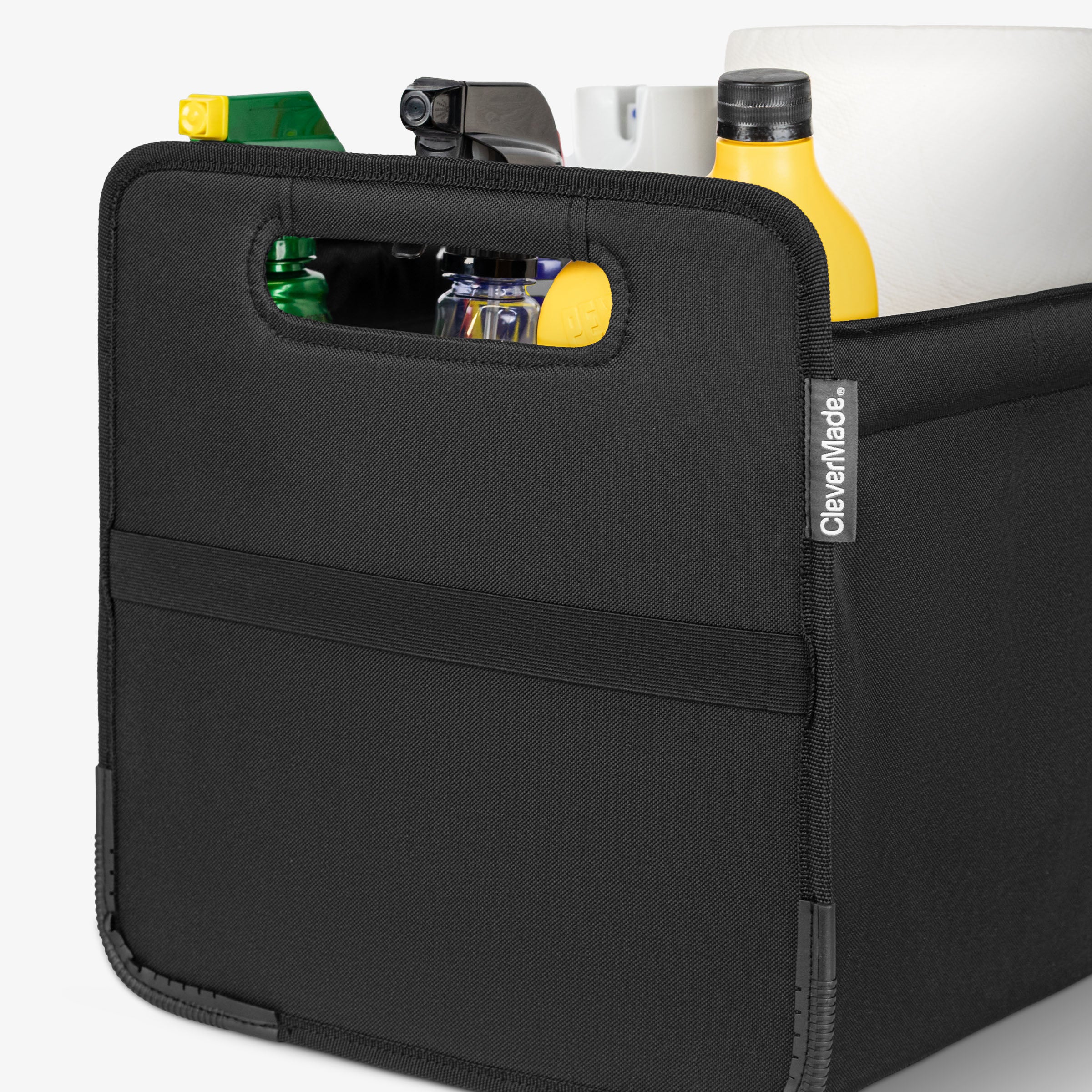 Black car trunk caddy with items inside on a white background