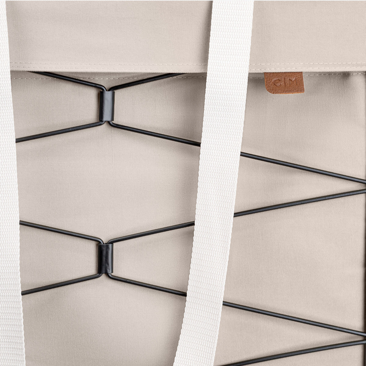 Close-up of a cream bag with a strap and metal frame detail