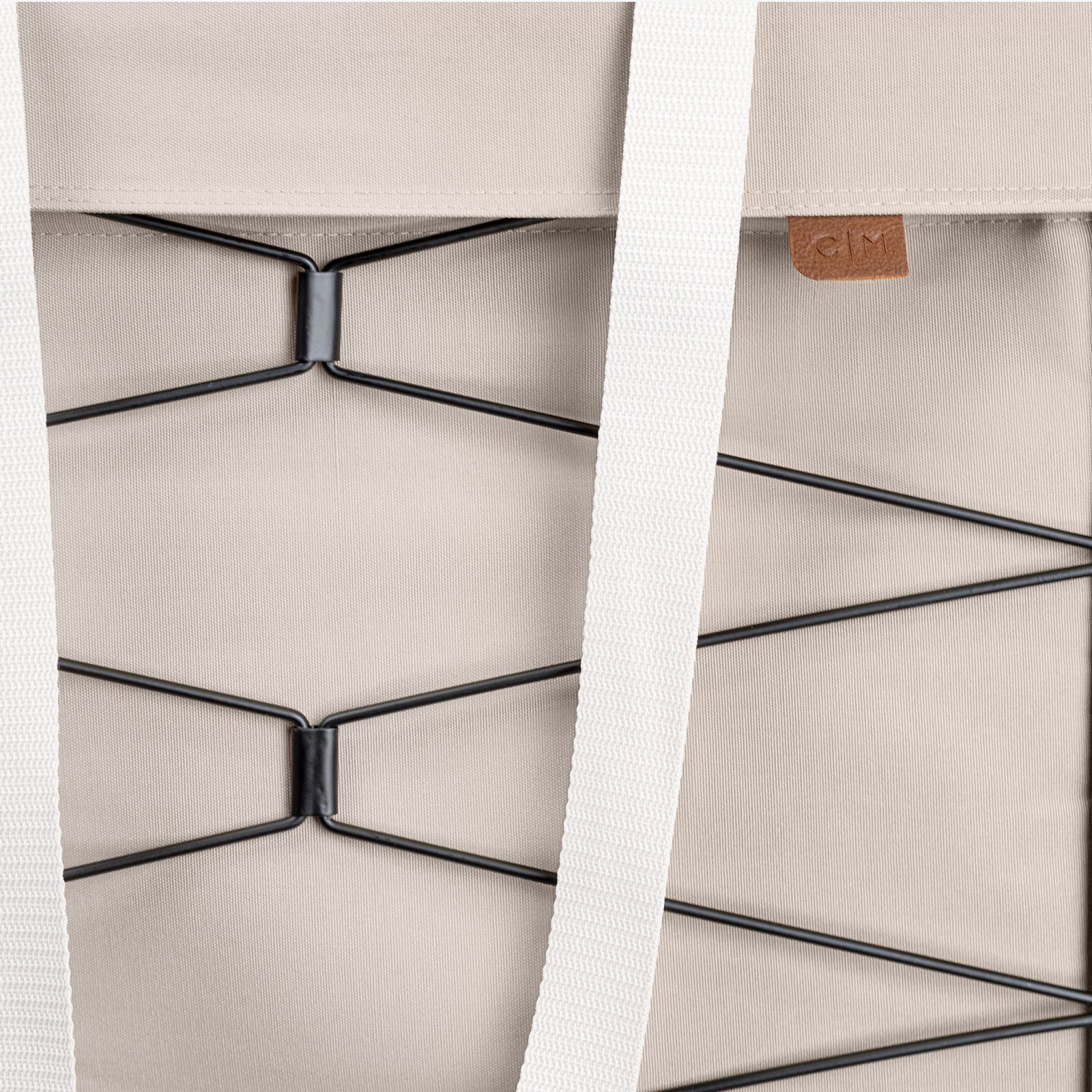 Close-up of a cream bag with a strap and metal frame detail