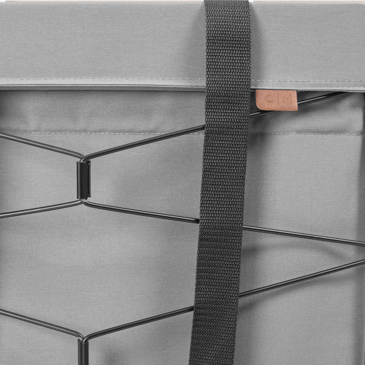 Close-up of a gray bag with a strap and metal frame detail