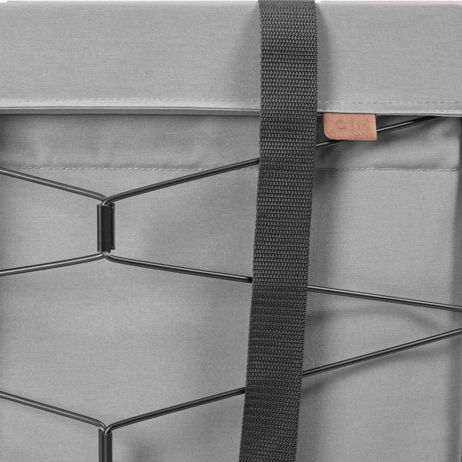 Close-up of a gray bag with a strap and metal frame detail