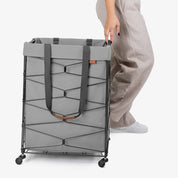 Person holding a gray laundry cart on a white background