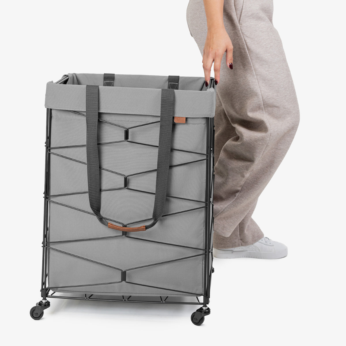 Person holding a gray laundry cart on a white background
